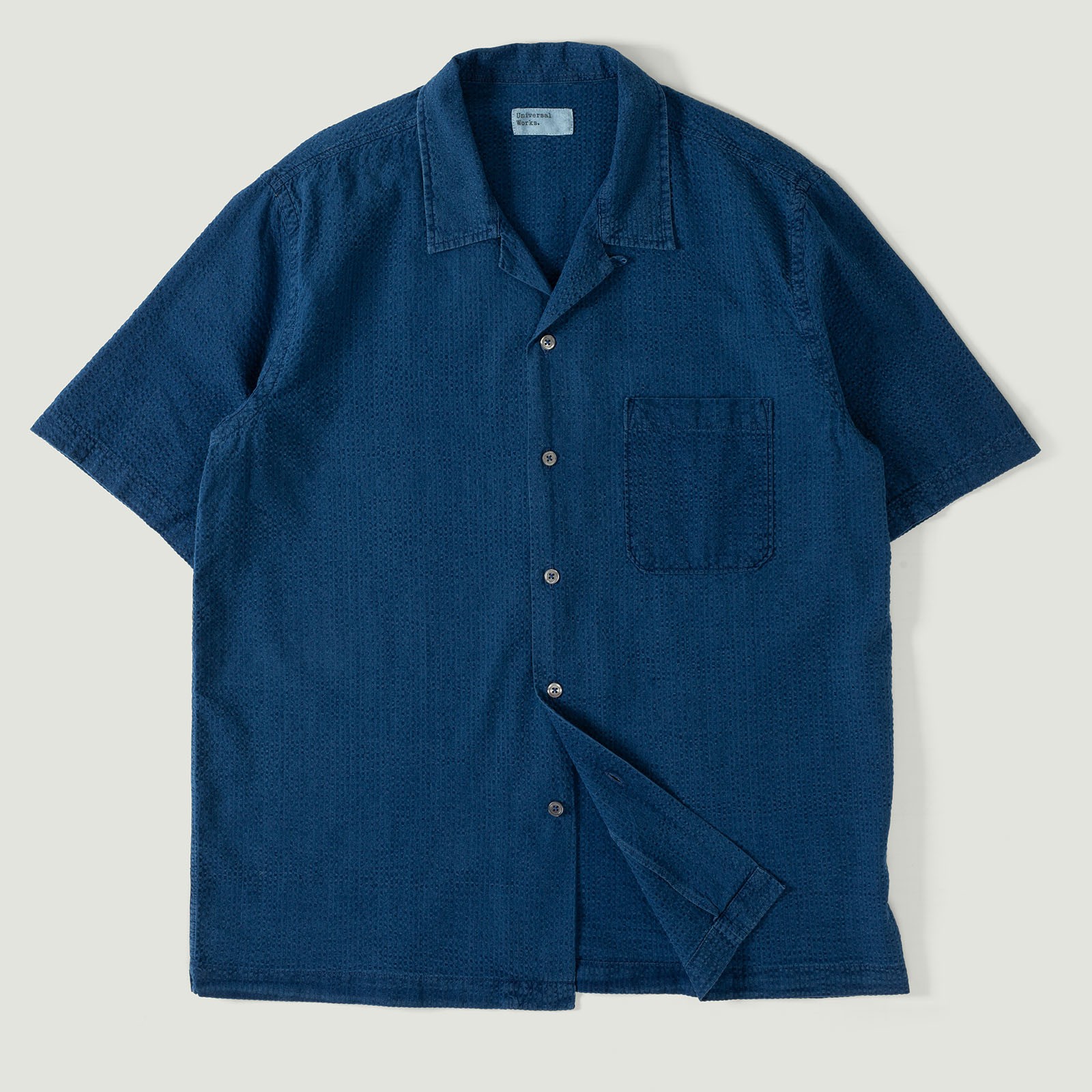 UNIVERSAL WORKS Road Shirt in Washed Indigo Seersucker with a vignette of loafers