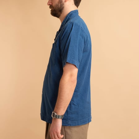 UNIVERSAL WORKS Road Shirt in Washed Indigo Seersucker worn side profile by a loafer