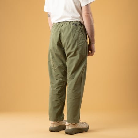 back view of GOHEMP High Explorer Pants in Olive Green worn by a person casually strolling