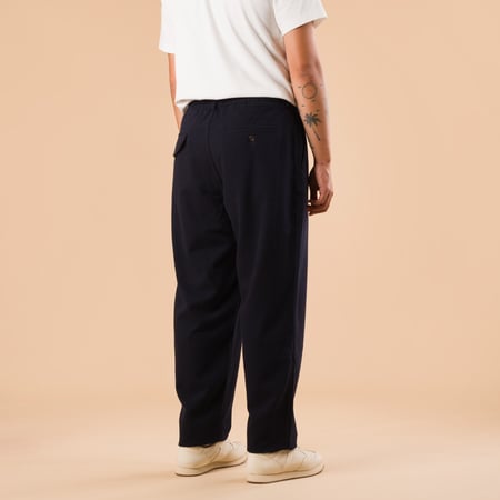 images flaneurs pantalon en laine UNIVERSAL WORKS Soft Recycled Wool Pleated Track Pant Dark Navy de dos