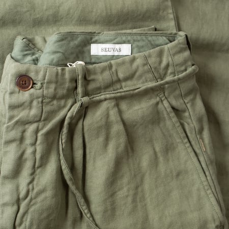 détail front flaneurs pantalon SEUVAS Linen Tapered 2-Tuck Pants Olive (1)