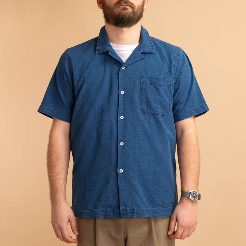 UNIVERSAL WORKS Road Shirt in Washed Indigo Seersucker, worn from the front, loafers.