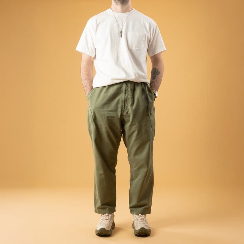 GOHEMP High Explorer Pants Olive Green, front view of the pants worn by a person casually strolling.