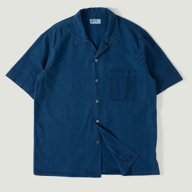 UNIVERSAL WORKS Road Shirt in Washed Indigo Seersucker with a vignette of loafers