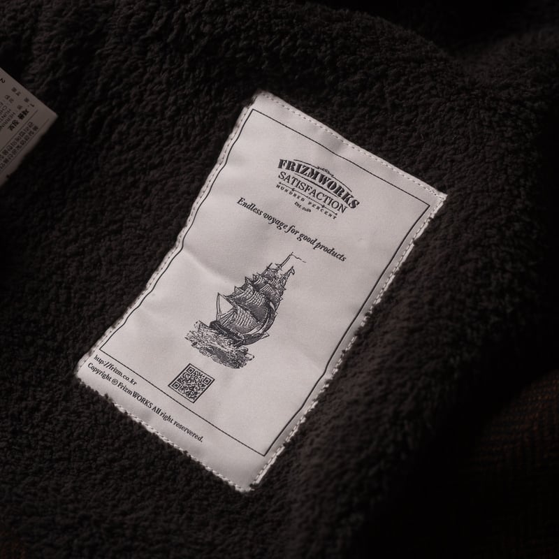 Image flâneurs FRIZMWORKS / Herringbone Wool Hunting Vest Chestnut Black détail tag